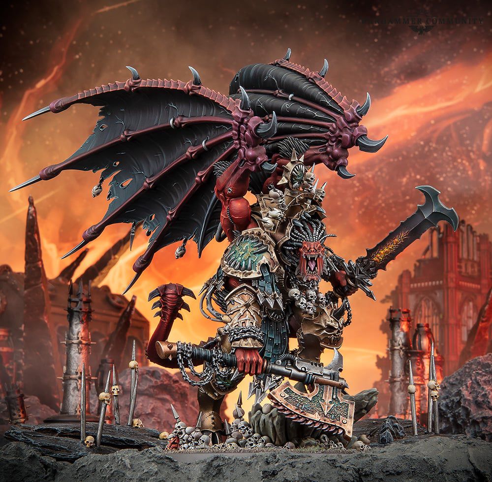 Warhammer 40,000: Angron, Primarch of the World Eaters new model, which depicts a massive red daemon wearing the remains of space marine armor, dual wielding a cruel sword and wicked chain axe, with great wings folded up in the air.