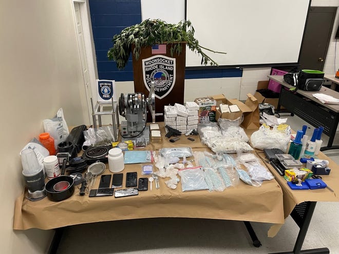The Woonsocket police display marijuana, fentanyl, guns and equipment seized Thursday.