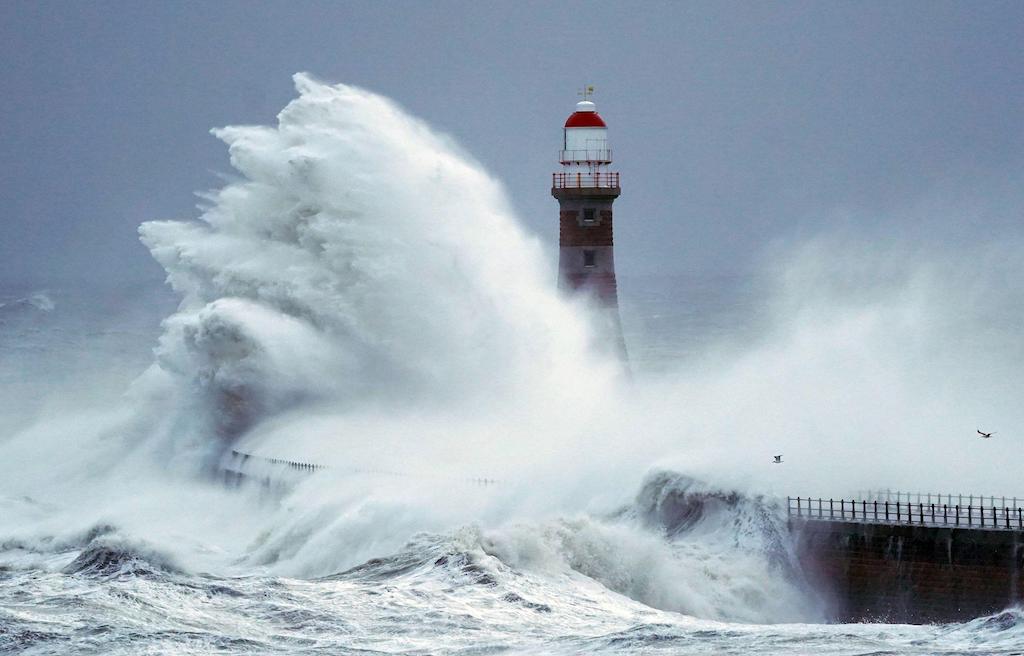 Huge waves crash the against the sea wall and Roker Lighthouse in Sunderland in the tail end of Storm Arwen, November 27 2021.